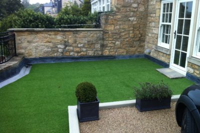 Garden and drive over a podium deck with basement below