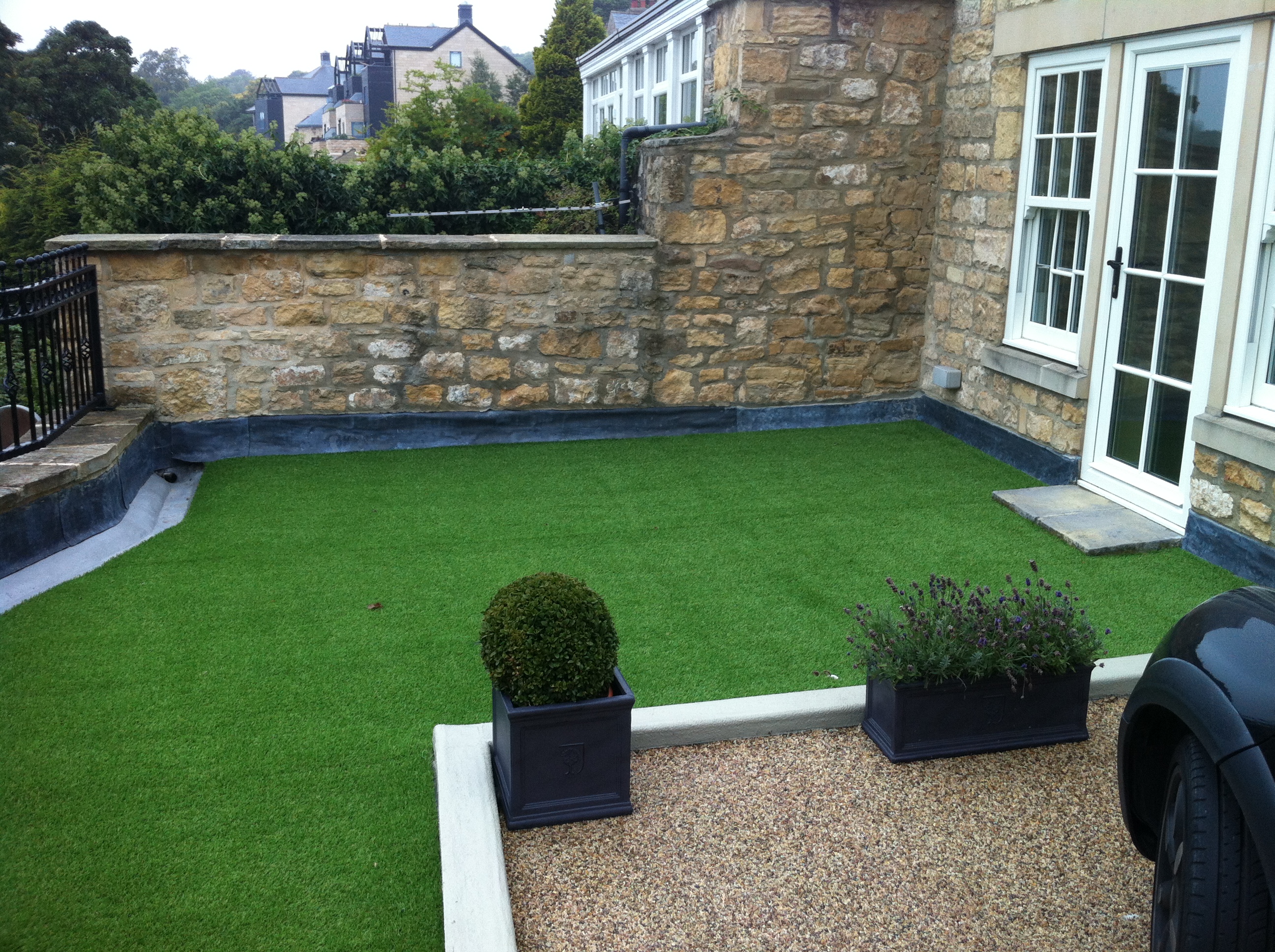 Garden and drive over a podium deck with basement below